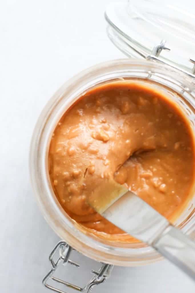 overhead shot of Oven Roasted Peanut Butter GOLD in clear glass jar 