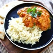 my favorite chicken tikka masala plated on a black dish with white trim, on top of a wood plate, served with naan. #chickentikkamasala #indianrecipes #indianfood #healthydinnerrecipes #chicken