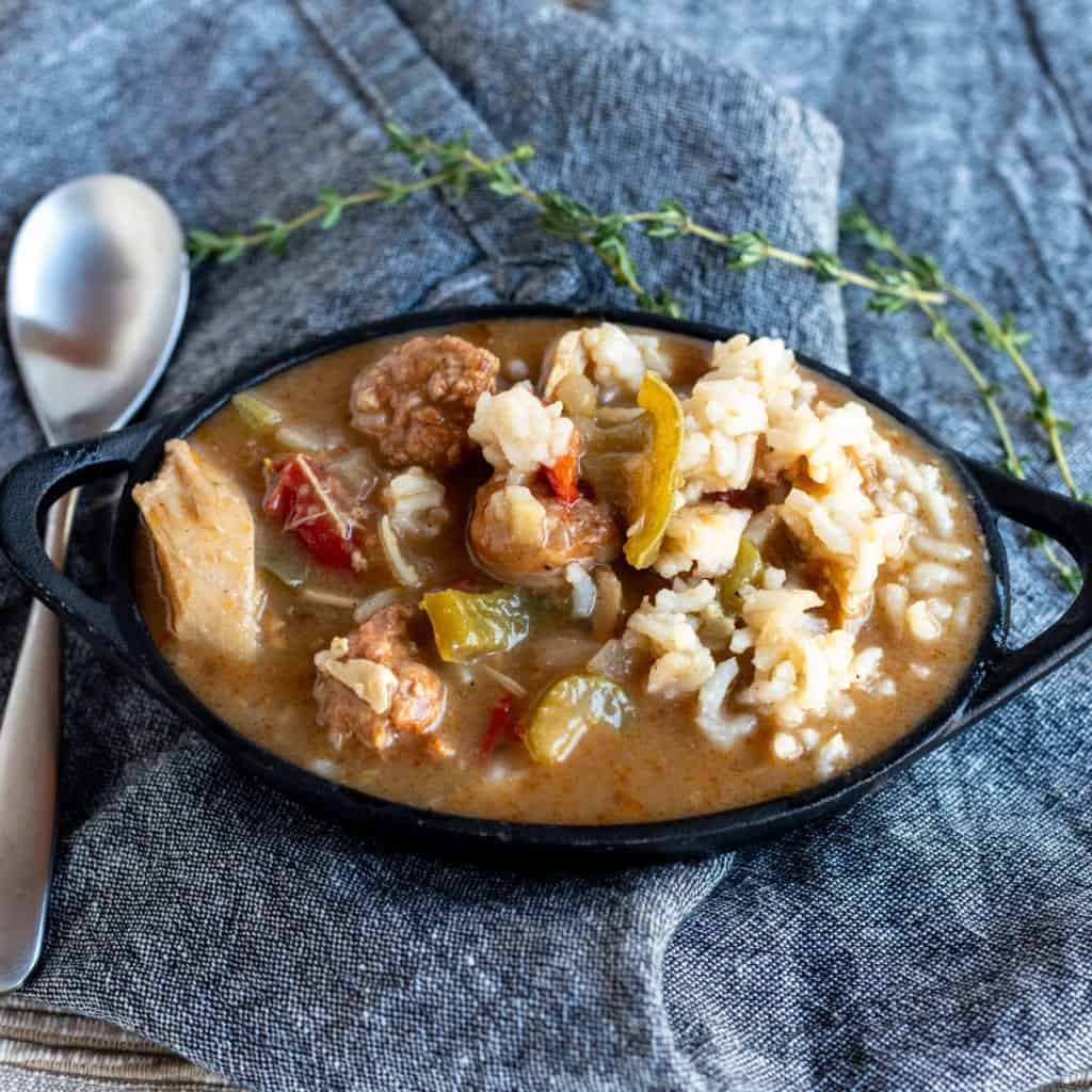 Leftover Turkey Andouille Gumbo served in a cast iron bowl with spoon on a denim napkin #feedfeed #f52grams #huffposttaste #ImSoMartha #thekitchn #eeeeeats #bhgfood #foodandwine #foodgawker #bareaders #fwx #beautifulcuisines #foodblogfeed #dailyfoodfeed #ktchn #comfortfoods #BuzzFeast #bingeworthybites #soup #stew #gumbo #turkeygumbo #thanksgivingleftovers #leftoverchicken #leftoverrecipes #lecreuset #leftovers #leftoverturkey #nomnomnom #onthetable 