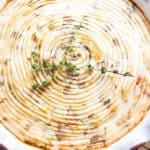 shepherd's pie with golden mashed potatoes and fresh thyme in pie dish on a butchers block with cooling rack and denim napkin. #shepherdspie #weightwatchers #ww #groundturkeyrecipe #irishrecipes #dinnerrecipes #cottagepie