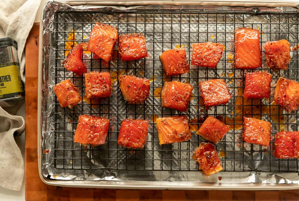 Marinated salmon bites on baking sheet ready to cook in the traeger with finn and feather seasoning.