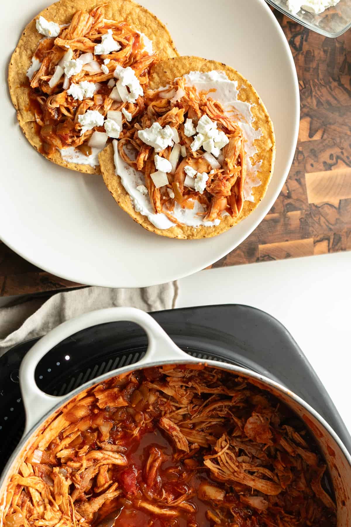 Spicy Chicken Tinga Tostadas with crumbled goat cheese on top 